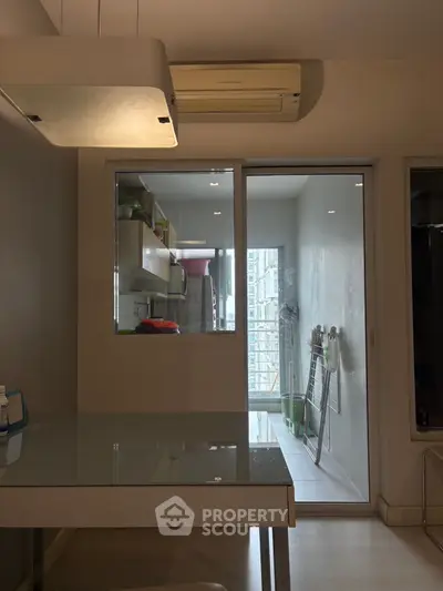 Modern kitchen with glass sliding door and air conditioning unit, featuring sleek design and ample natural light.