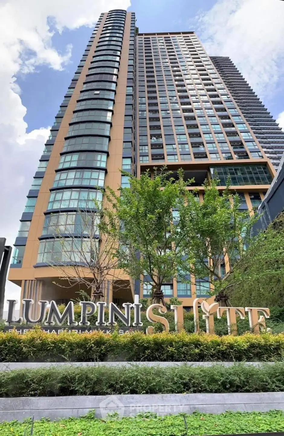 Stunning modern high-rise building with lush greenery at Lumpini Suite.