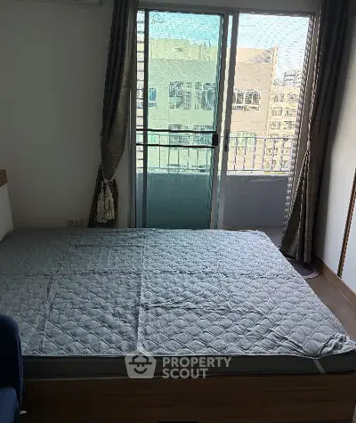 Cozy bedroom with large window and city view, featuring a comfortable bed and elegant curtains.