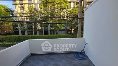 Spacious balcony with urban view and greenery, perfect for relaxation.