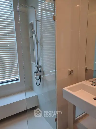 Modern bathroom with glass shower and sleek white sink