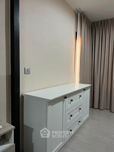 Modern bedroom with elegant white dresser and floor-to-ceiling curtains