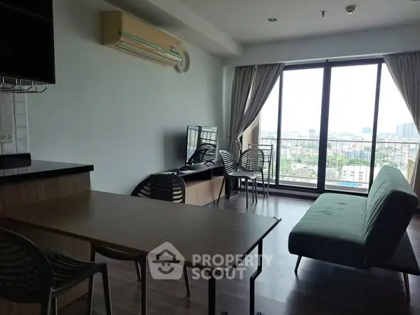 Modern living room with large windows and city view, featuring sleek furniture and air conditioning.