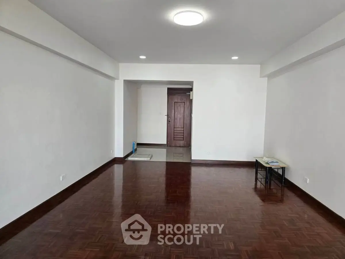 Spacious empty living room with wooden flooring and bright lighting