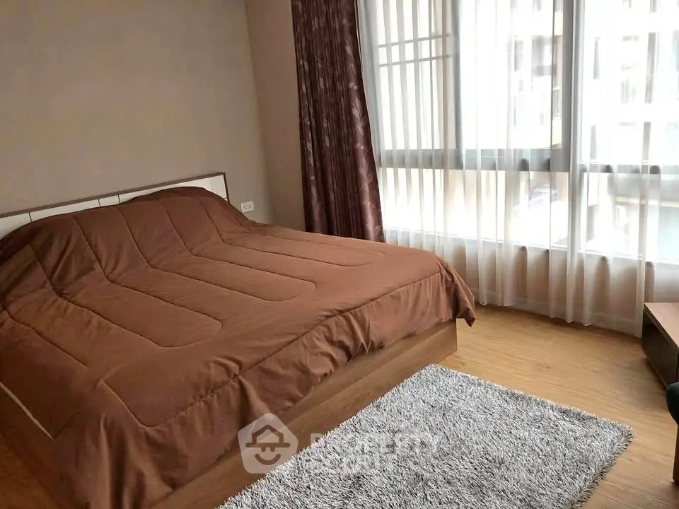 Spacious bedroom with large windows and cozy decor in modern apartment