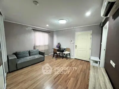 Spacious living room with modern decor and wooden flooring, perfect for cozy gatherings.