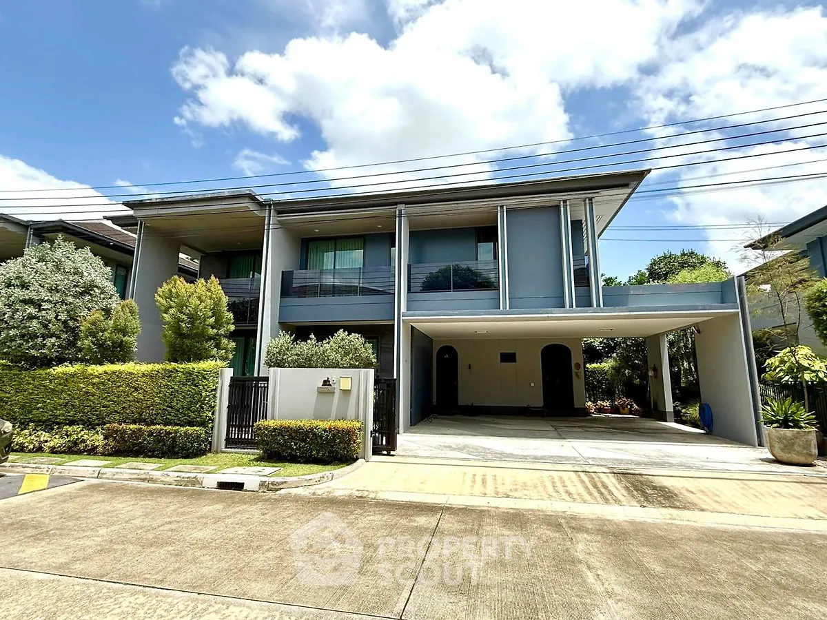 Modern two-story house with spacious driveway and lush greenery