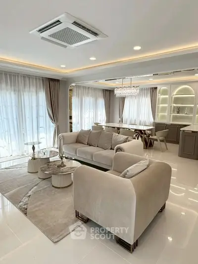 Luxurious living room with elegant decor and open layout, featuring plush seating and modern lighting.