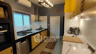 Modern kitchen with sleek design, featuring yellow cabinets, marble countertops, and stainless steel appliances.