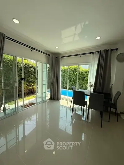 Bright dining area with pool view and large windows in modern home