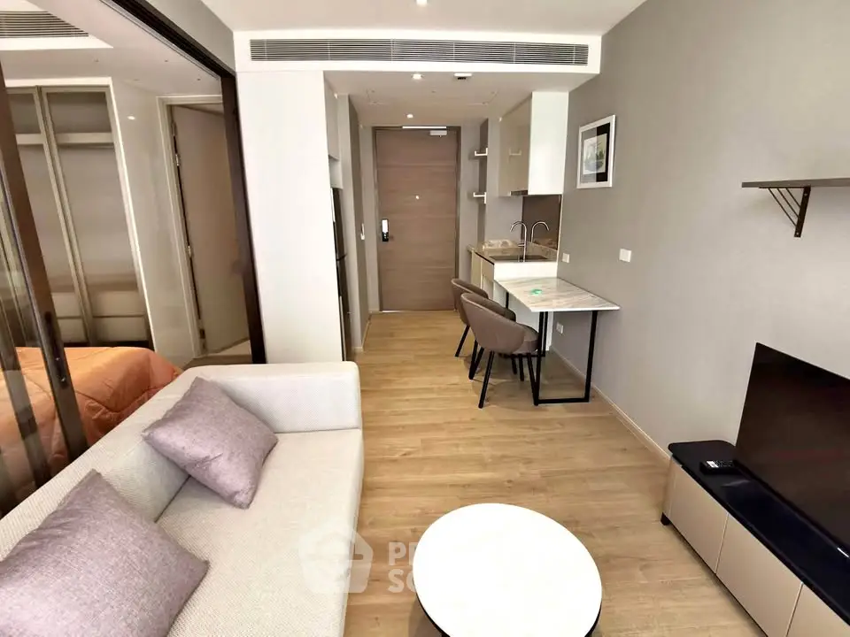 Modern studio apartment with cozy living area and compact kitchen, featuring stylish decor and efficient layout.