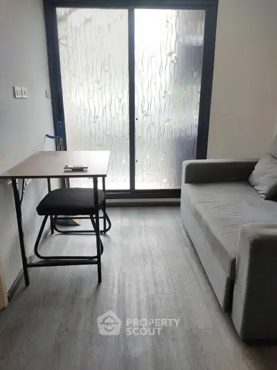 Cozy living room with modern sofa and compact table near frosted glass door.