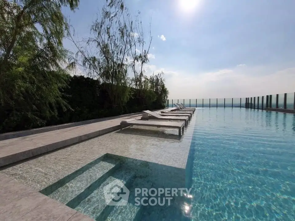 Luxurious rooftop infinity pool with sun loungers and stunning skyline views.