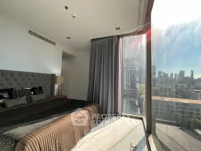 Luxurious bedroom with floor-to-ceiling windows offering stunning city views and elegant decor.