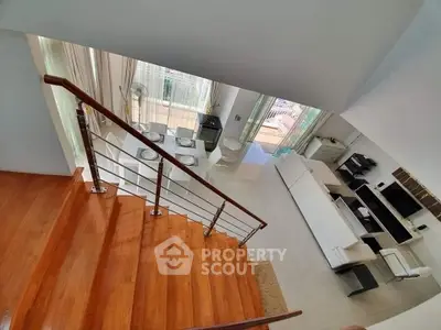 Spacious modern living room with elegant staircase and abundant natural light