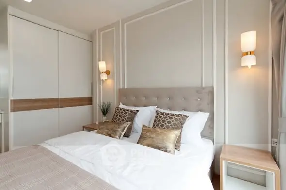 Luxurious modern bedroom with elegant decor and plush bedding in a stylish apartment.