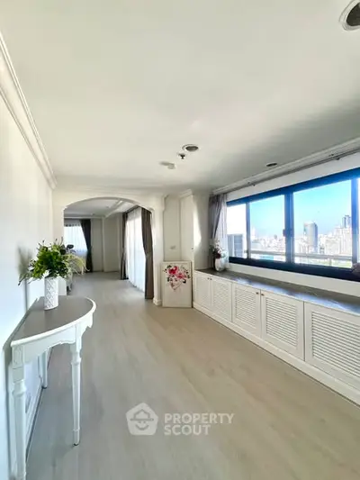 Spacious and bright living area with panoramic city views and elegant decor.