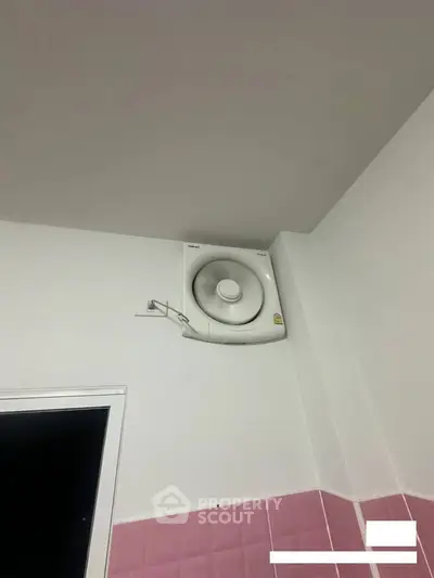 Modern bathroom with wall-mounted ventilation fan and pink tiles