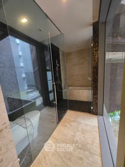 Luxurious modern bathroom with glass shower and elegant stone tiles
