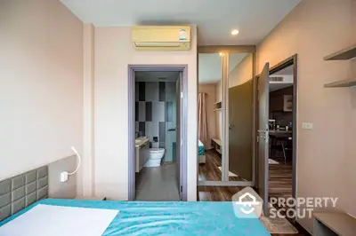 Modern bedroom with ensuite bathroom and air conditioning in stylish apartment.