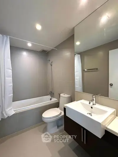 Modern bathroom with sleek fixtures and a bathtub in a contemporary apartment.