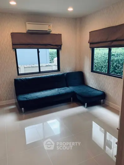 Cozy living room with modern L-shaped sofa and large windows for natural light.
