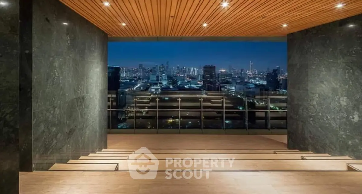 Stunning cityscape view from a modern building's rooftop terrace at night.
