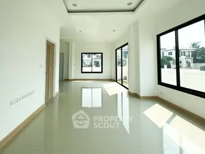 Spacious modern living room with large windows and abundant natural light