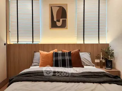 Cozy bedroom with modern decor and stylish artwork, featuring warm lighting and plush pillows for ultimate comfort.