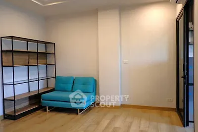 Modern living room with blue sofa and stylish shelving unit