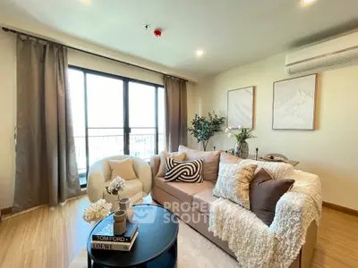 Stylish living room with cozy sofa, elegant decor, and large window for natural light