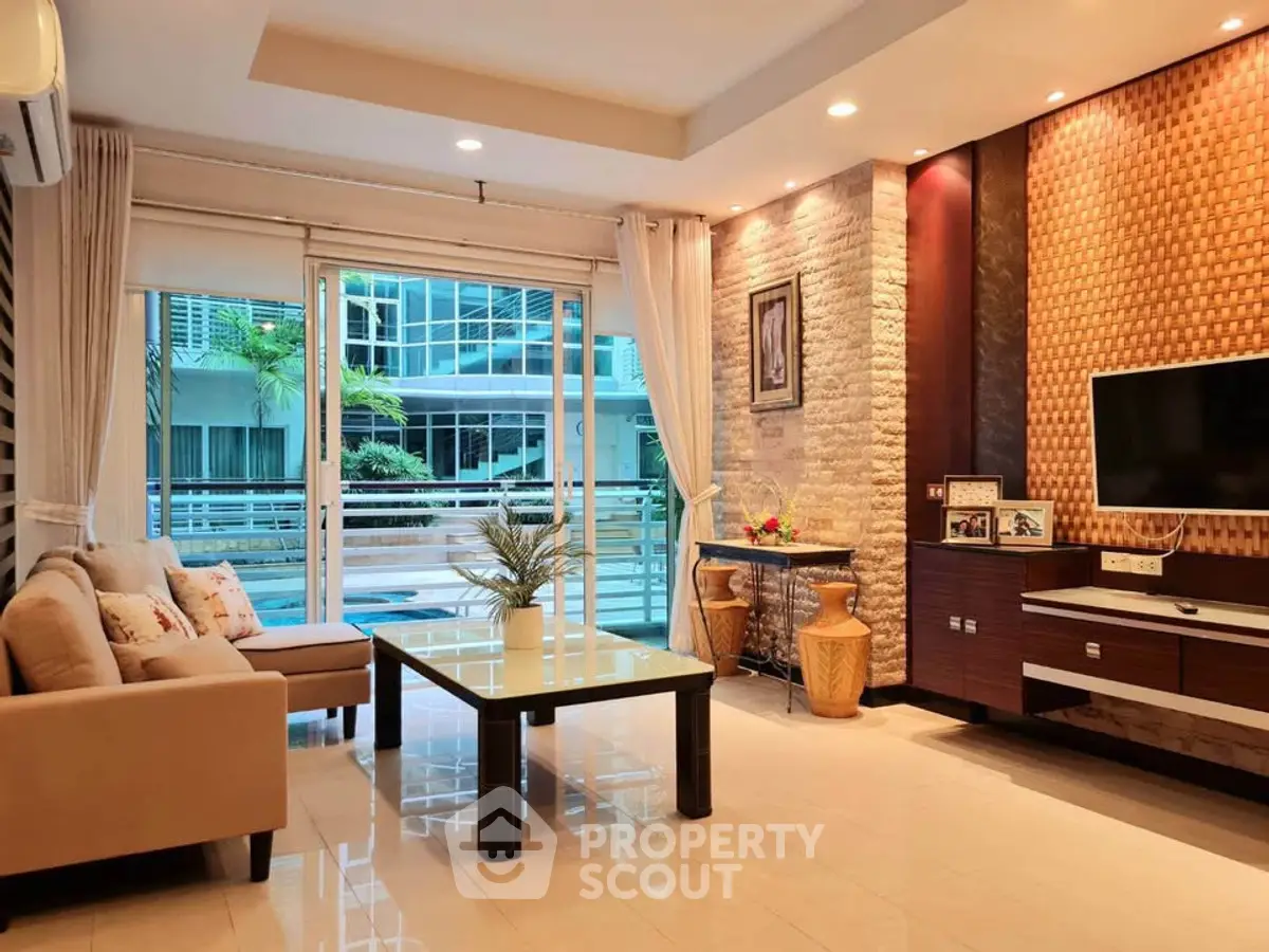 Modern living room with elegant decor and large windows overlooking balcony.