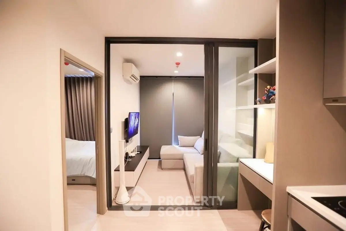 Modern apartment interior with cozy living room and adjacent bedroom, featuring sleek design and neutral tones.