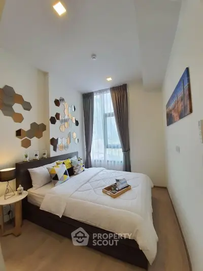 Modern bedroom with stylish decor and large window in a contemporary apartment.