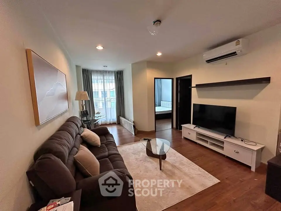 Spacious living room with modern decor and natural light in a stylish apartment.