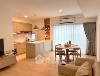 Modern open-layout kitchen and dining area with natural light and stylish decor.