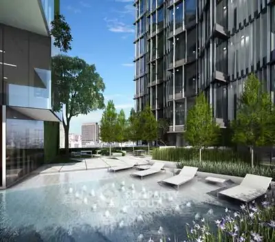 Luxurious modern apartment building with serene pool and lush greenery.