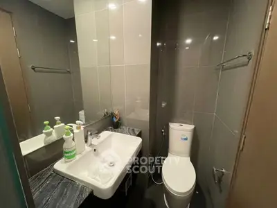 Modern bathroom with sleek fixtures and elegant design, featuring a stylish sink and toilet.