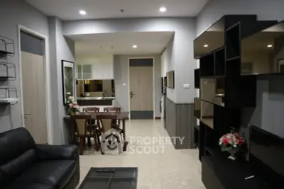 Modern living room with sleek furniture and open dining area in a stylish apartment.