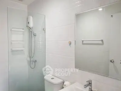 Modern bathroom with glass shower and sleek fixtures in a contemporary home.