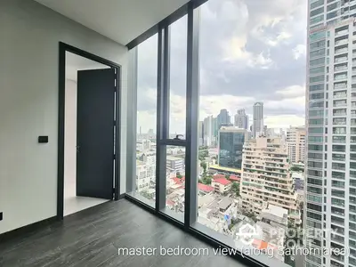 Spacious master bedroom with floor-to-ceiling windows offering panoramic city views, modern design, and abundant natural light, ideal for urban living.