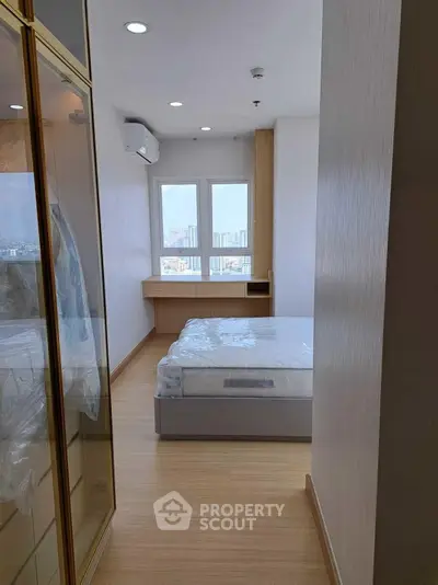 Modern bedroom with city view, featuring sleek design and natural light.