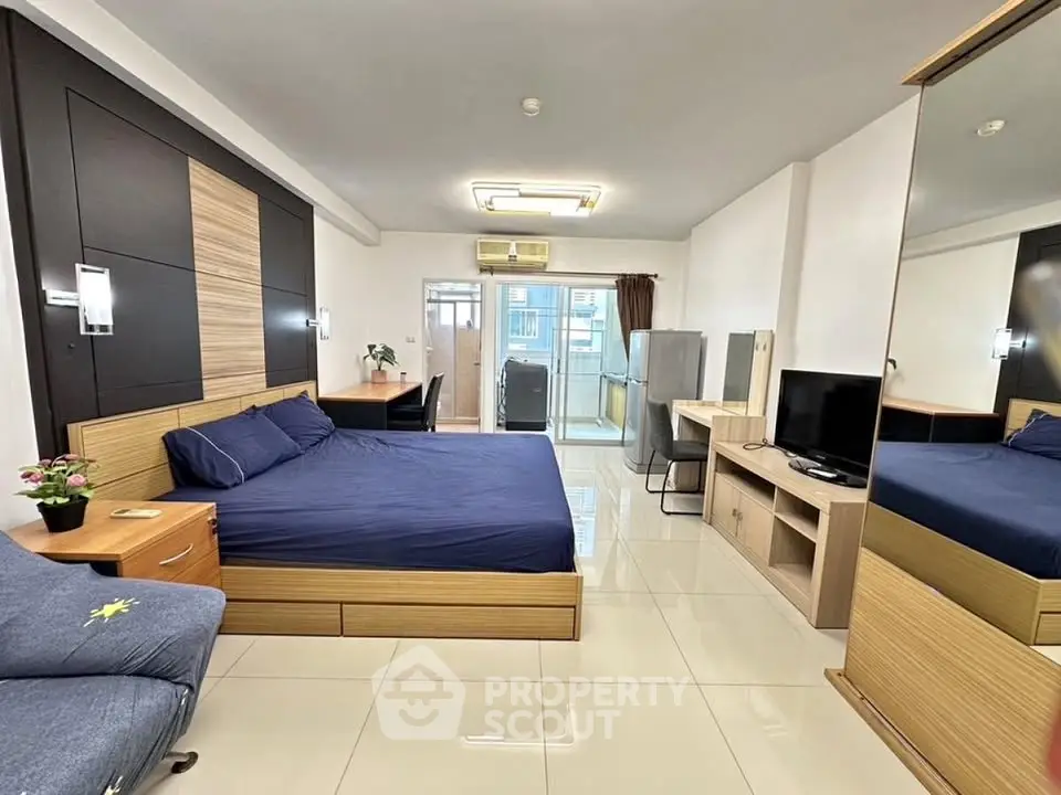 Spacious modern bedroom with sleek design and balcony access in a stylish apartment.