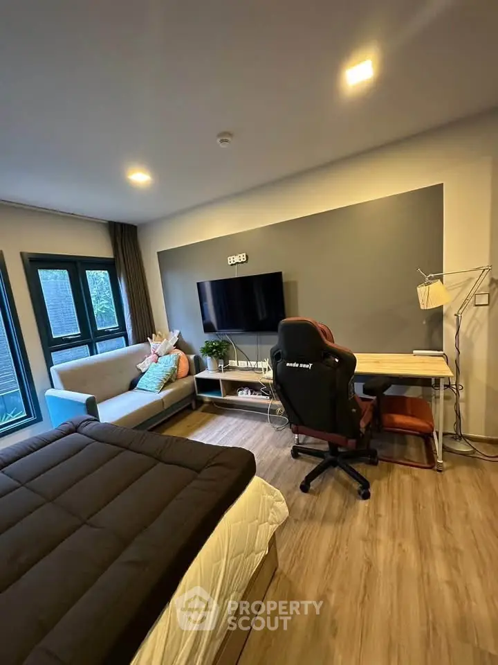 Modern studio apartment with cozy living area and workspace, featuring stylish decor and natural light.