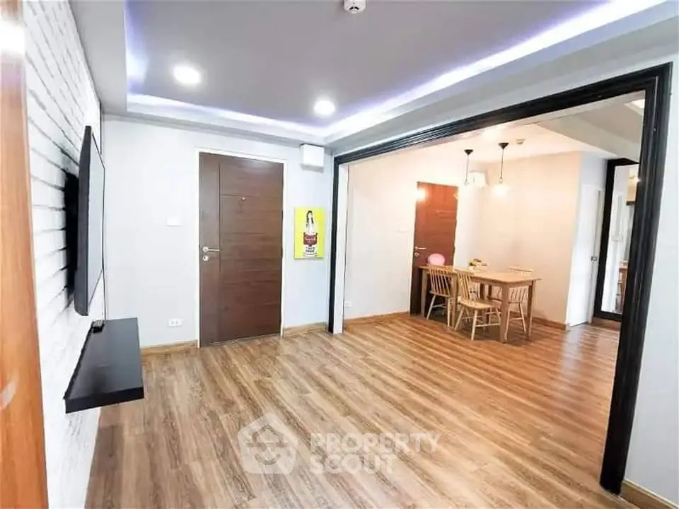 Spacious modern living room with open dining area and stylish wooden flooring.