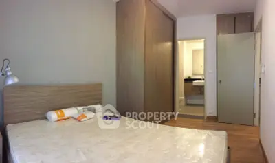 Modern bedroom with ensuite bathroom and wooden wardrobe in stylish apartment.