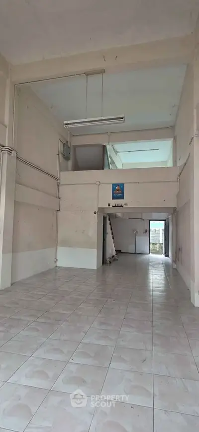 Spacious commercial property with high ceilings and tiled flooring, ideal for retail or office space.
