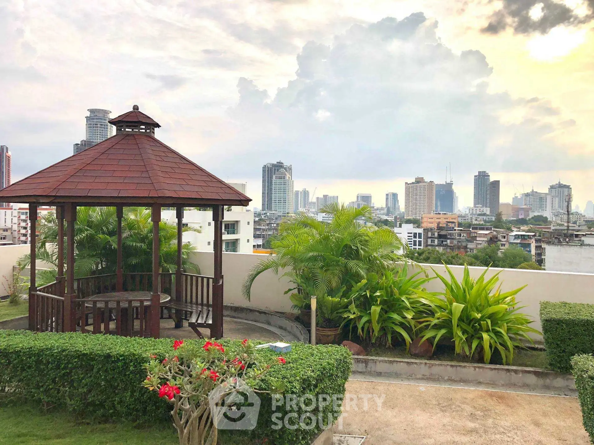 Stunning rooftop garden with city skyline view, featuring a charming gazebo and lush greenery.