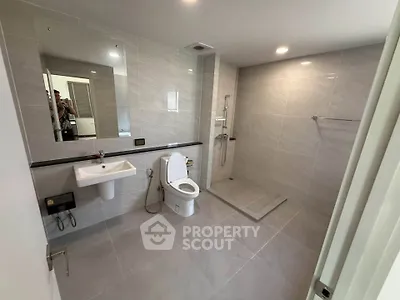 Spacious modern bathroom with sleek fixtures and open shower design.