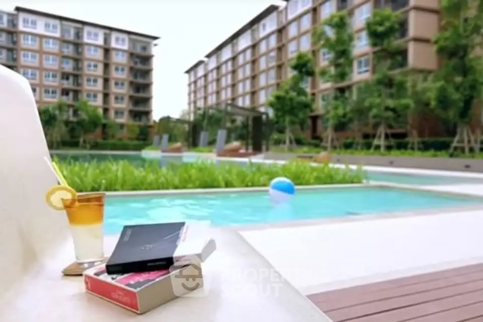 Luxurious poolside view with modern apartment backdrop and refreshing drink